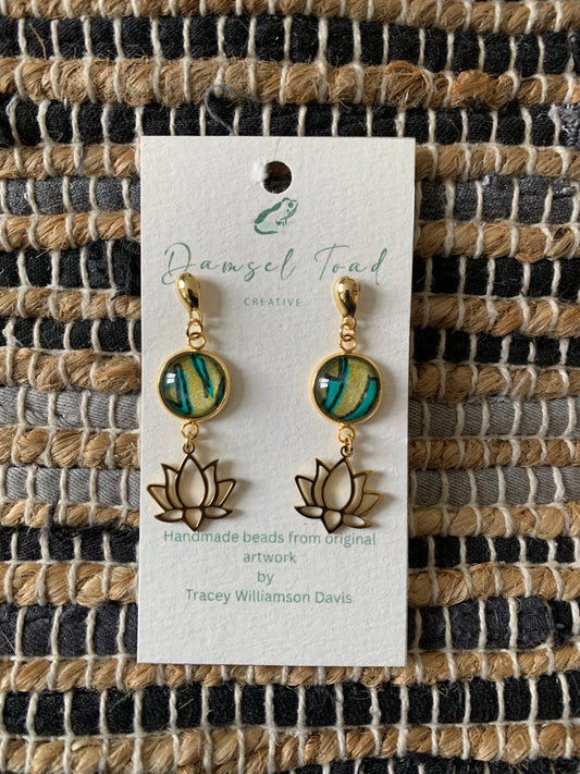 Pair of earrings on a card with 'Damsel Toad' branding against a woven fabric background